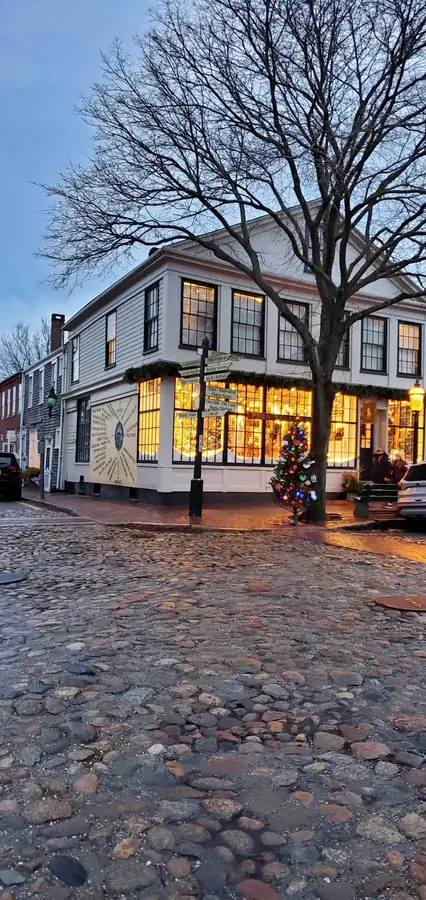 Glowing shop windows on a cobblestone corner at dusk