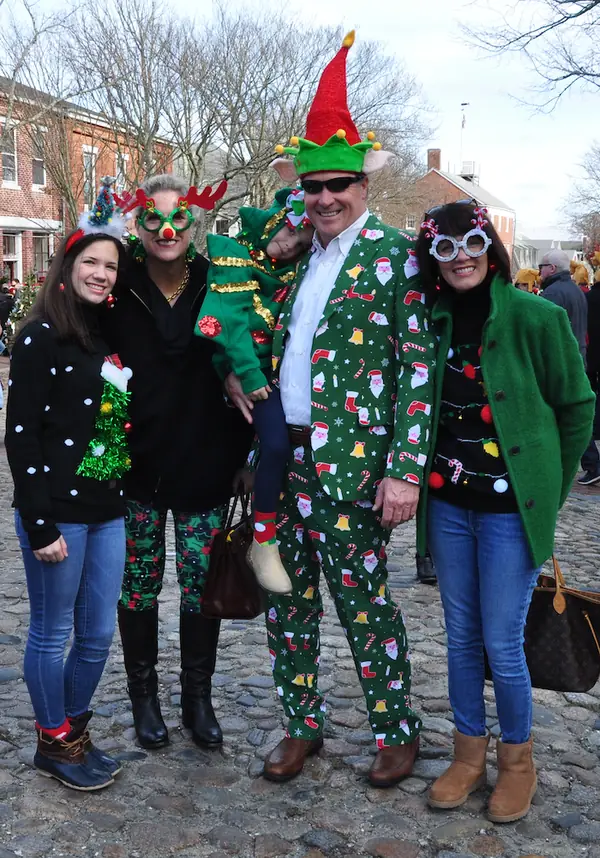 Family in festive holiday suits and elf hats on Main Street