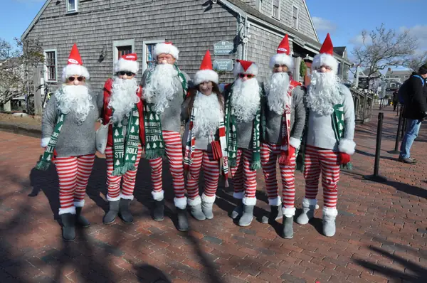 A group dressed as Santas in striped pants and Stroll scarves